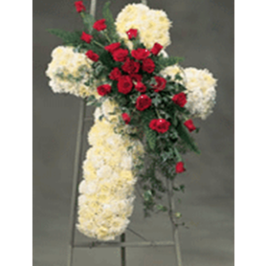 A cross of flowers with red roses on it.