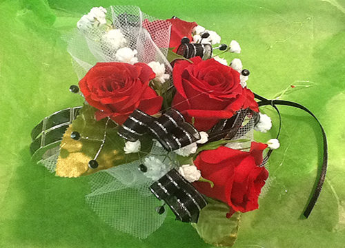 A bouquet of roses with black and white ribbon.