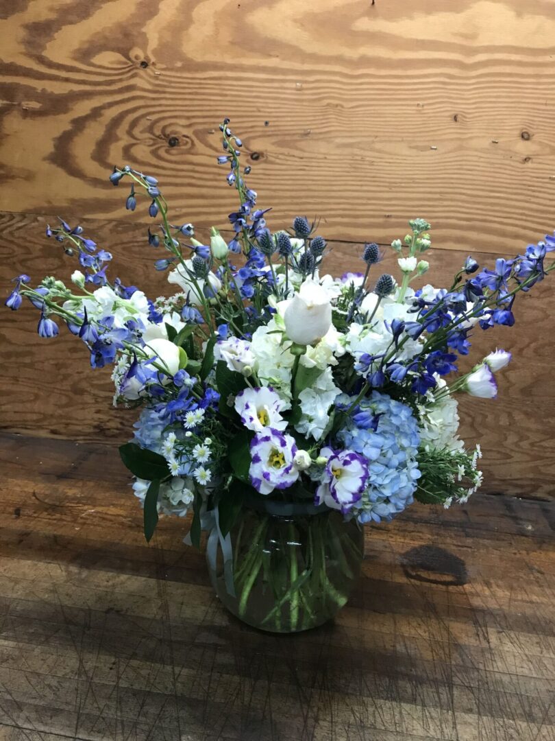A vase filled with blue and white flowers on top of a table.
