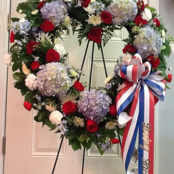 A wreath of flowers is on display in front of the door.
