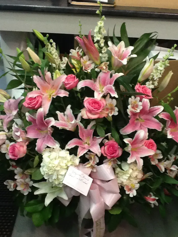 A bouquet of pink flowers with white and green leaves.